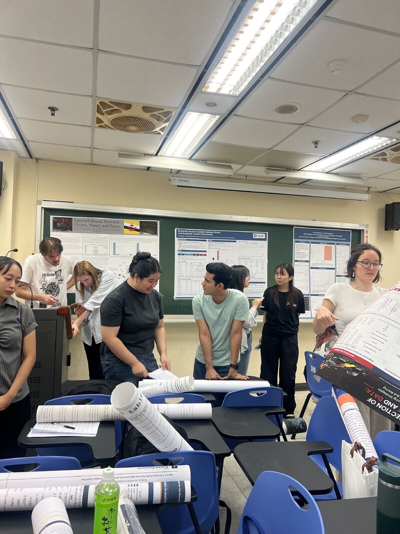 Students discuss research posters displayed around a classroom after analyzing the Epstein Files Database.