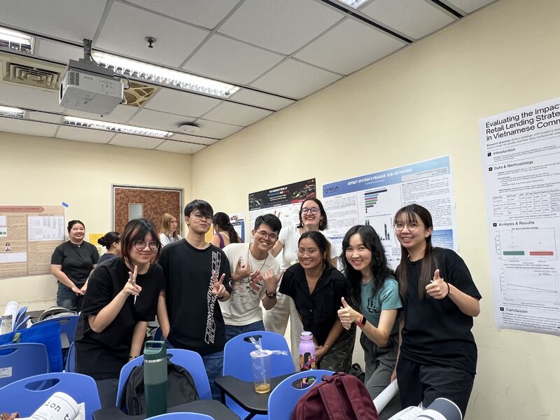 A group of students poses in front of research posters at the Data Science seminar poster session.
